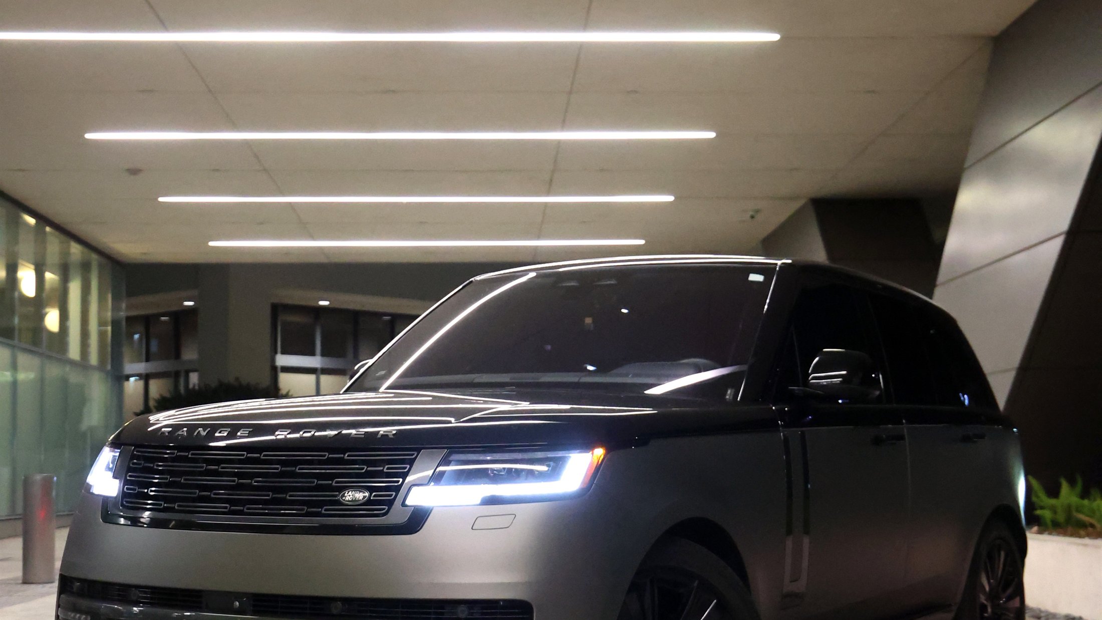 Range Rover lit at night under a modern canopy